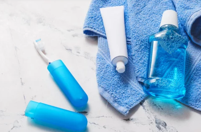 toothbrush, toothpaste, mouthwash and a towel