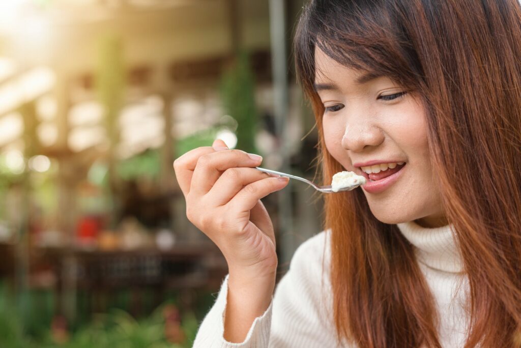 a woman holding a spoon near her mouth