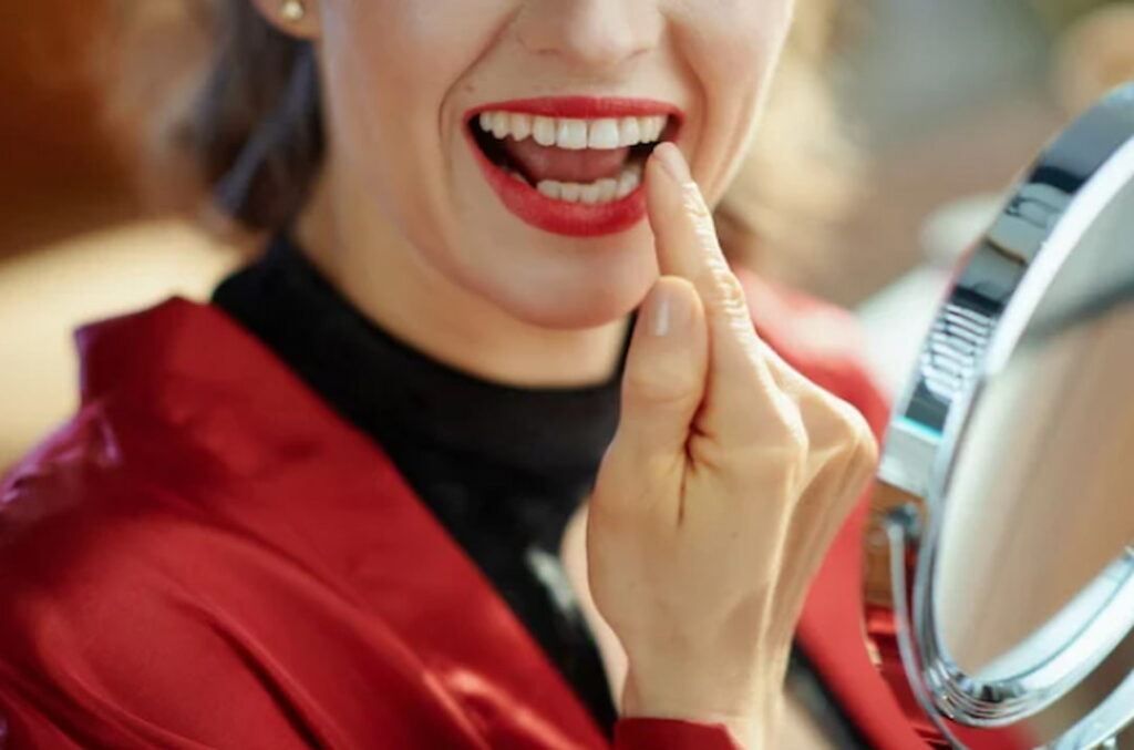 a woman showing her tooth in front of the mirror