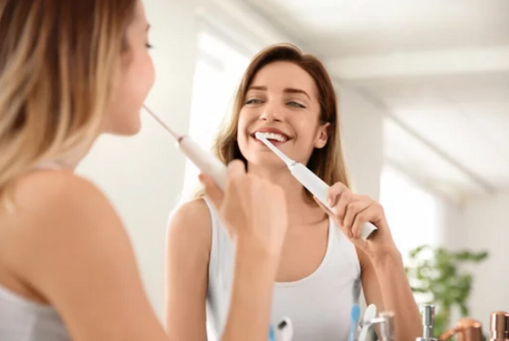 a woman brushing her teeth in front of the mirror