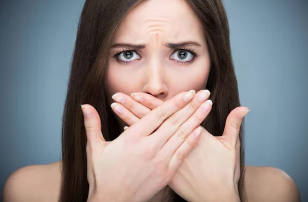 a girl covering her mouth with hands