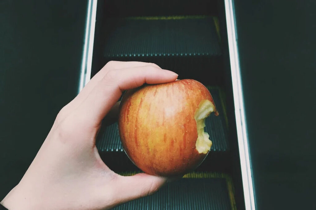 a person holding a bitten apple