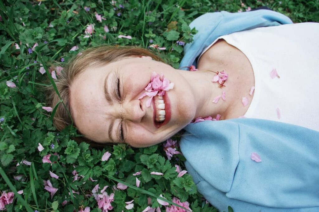 a woman lzing down in the grass and laughing