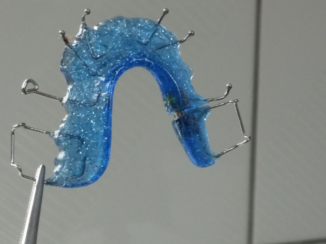 a person holding retainer with tweezers