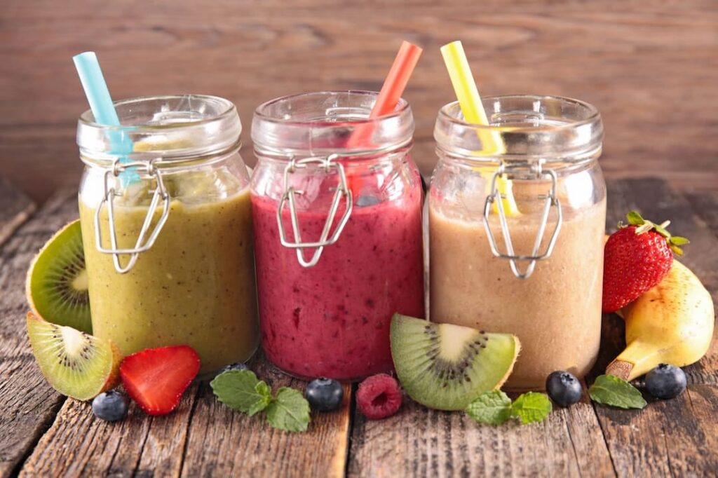 smoothies in jars and fruit on the table